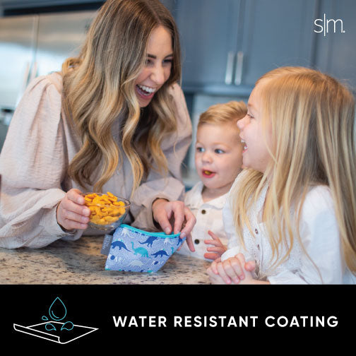 Woman in beige cardigan holding Ellie Snack Bag on granite countertop with bright blue accents