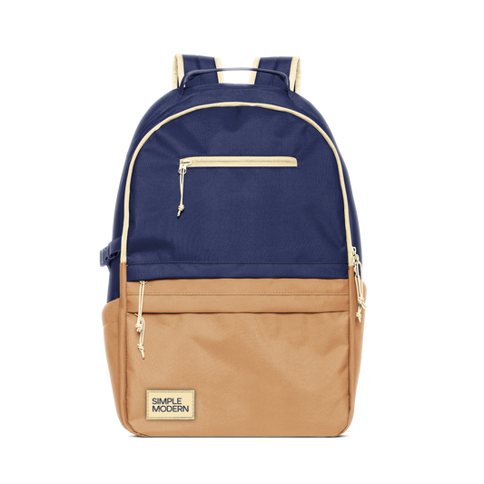 Two-tone navy blue and tan backpack with cream trim and hardware